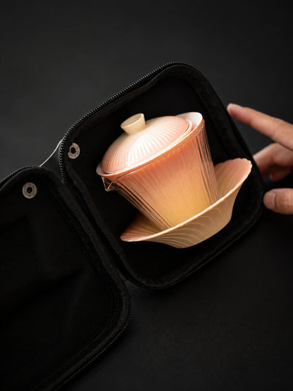 Gradient ceramic gaiwan and saucer nested inside an open travel case
