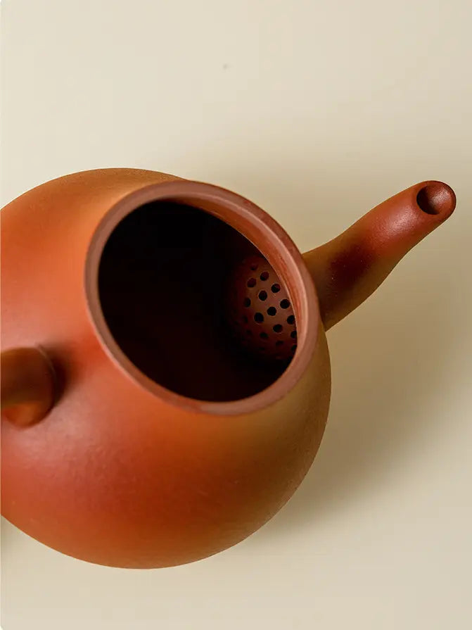 Open zisha teapot showing the built-in multi-hole filter
