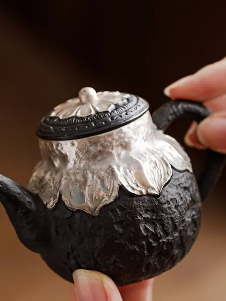 Close-up of the black zisha teapot lid, curved handle, and textured clay
