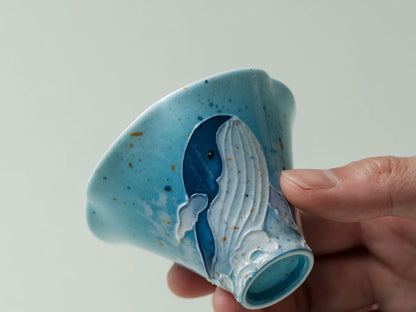 Close-up of the raised whale design and foot ring on the handmade ceramic tea cup