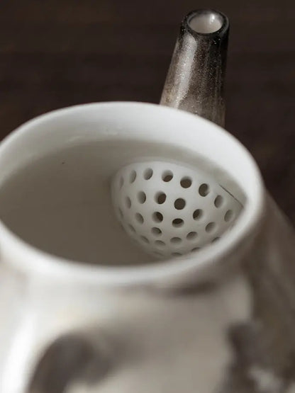 Interior view of the ceramic teapot with a built-in ball-hole tea strainer