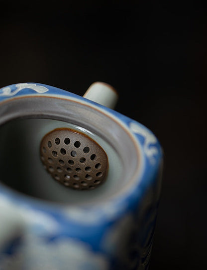 Close-up of the built-in multi-hole filter inside the ceramic teapot
