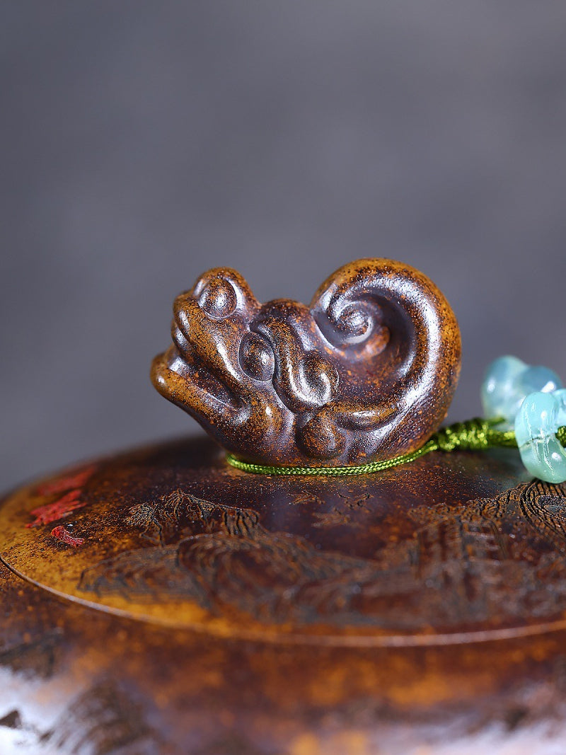 Close-up of the sculpted dragon lid knob and green flower-shaped bead on the Yixing zisha teapot
