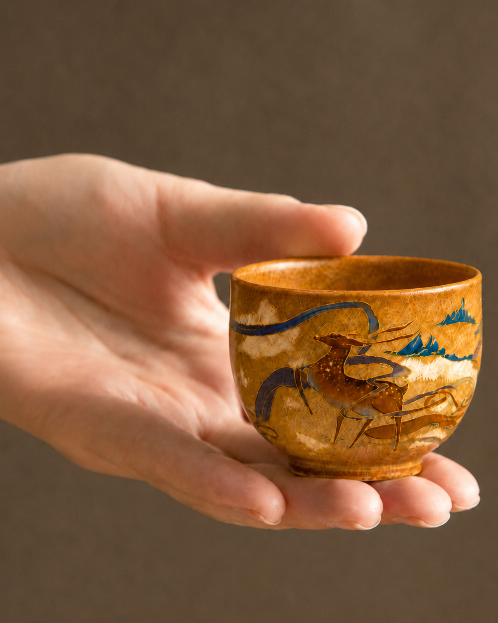 Hand holding the small 50 ml ceramic tasting cup to show its true-to-life scale