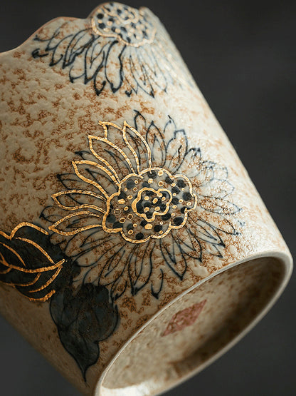 Close-up of the reactive glaze and gold-toned floral detailing on the ceramic cup

