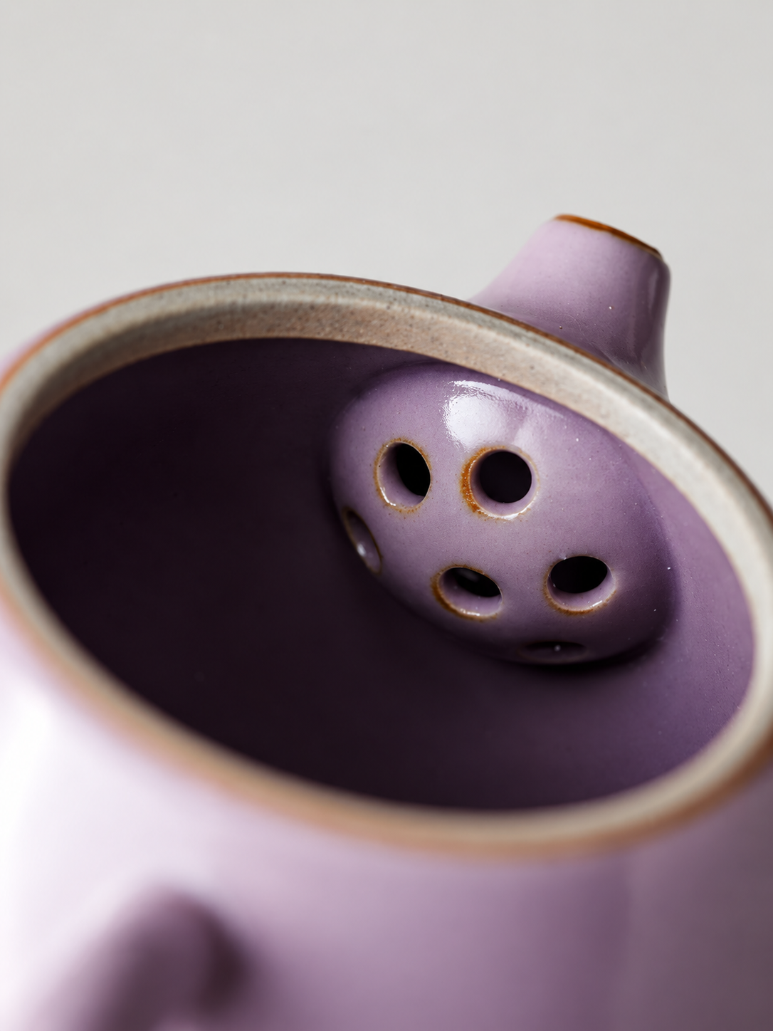 Built-in filter holes inside the purple ceramic teapot
