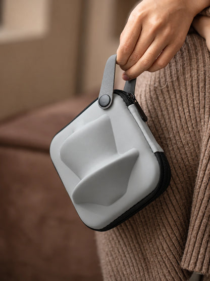 Gray molded travel tea case carried by its loop handle
