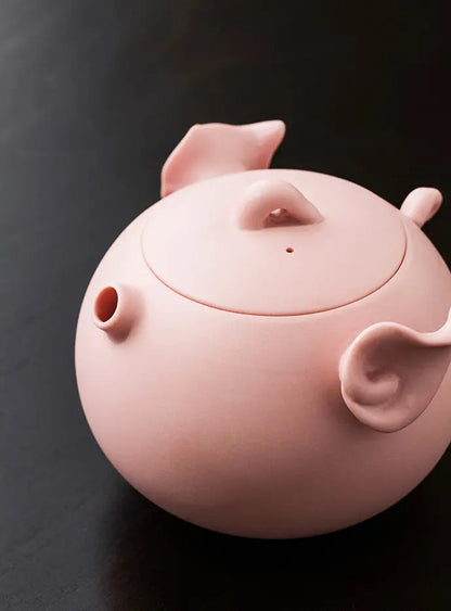 Close-up of the pink zisha pig teapot surface and sculpted ear detail
