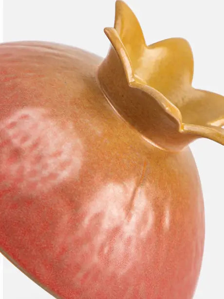 Close-up of the gold-toned pomegranate crown on the host cup
