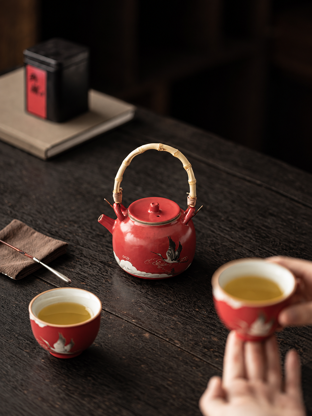 Two-person tea setting with a red crane teapot and matching ceramic cups
