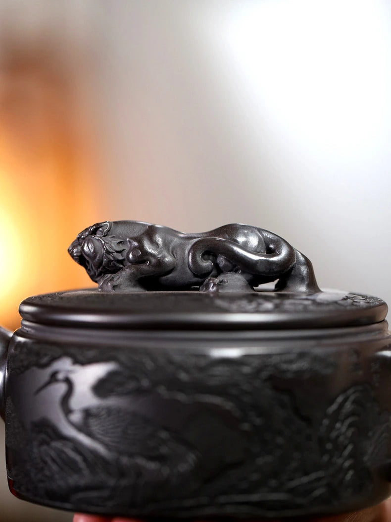Close-up of the sculpted reclining tiger knob on the carved Yixing zisha teapot