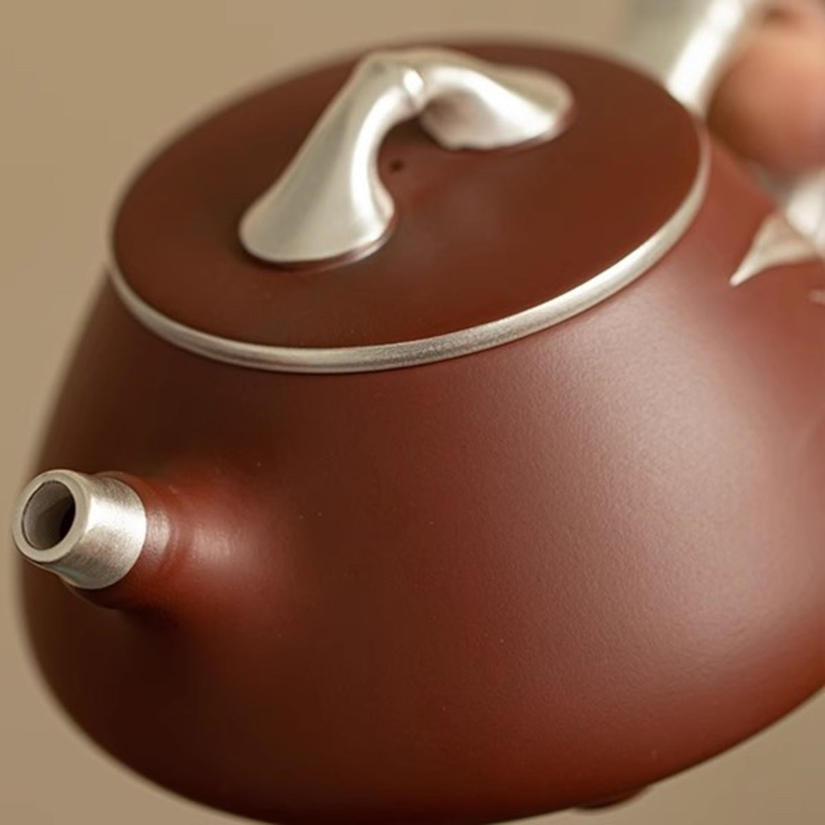 Close-up of the short spout, silver-tone lid rim, and bamboo-shaped lid knob