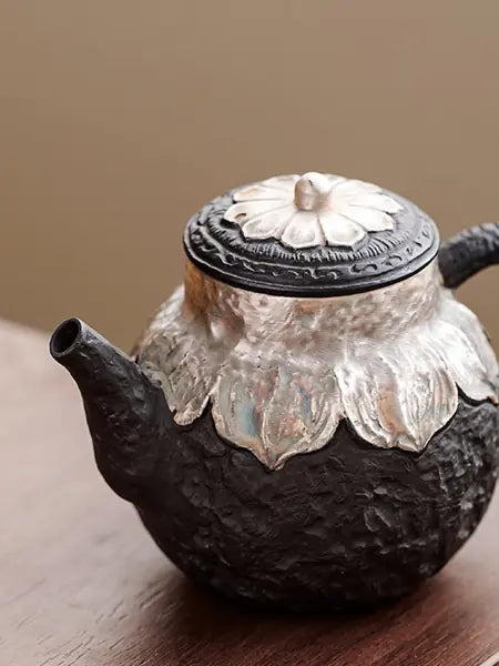 Close-up of the short spout, lotus collar, and textured black clay body
