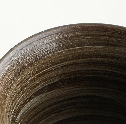 Close-up of the dark ceramic cup interior with natural circular brushwork