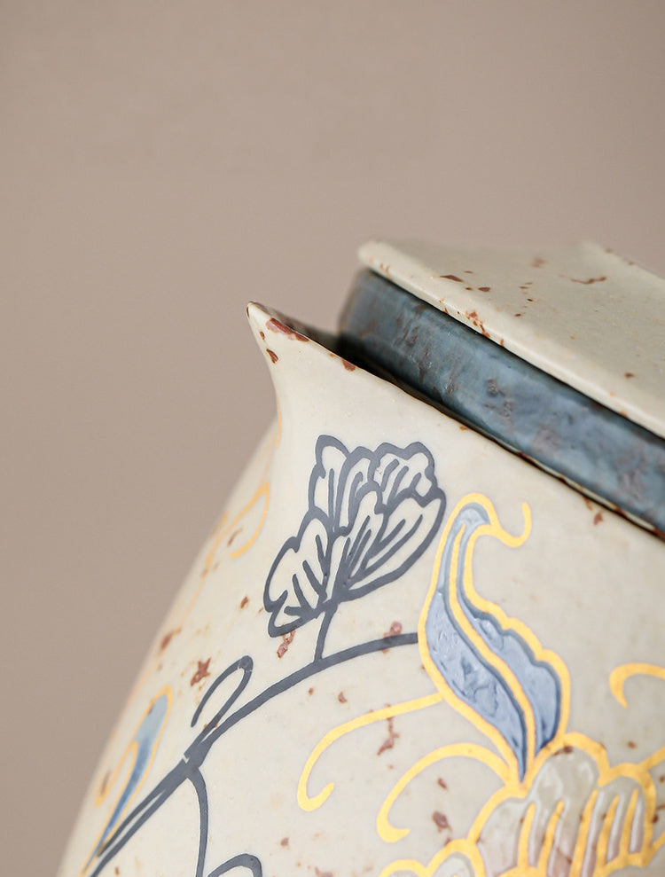 Close-up of the notched spout and peony decoration on the ceramic teapot
