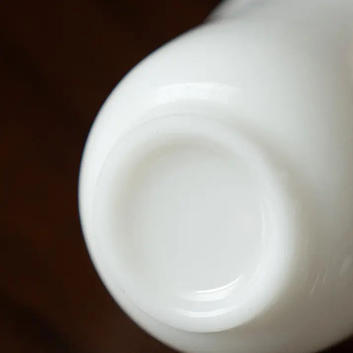 Close-up of the flat ring foot on the base of a white ceramic teapot
