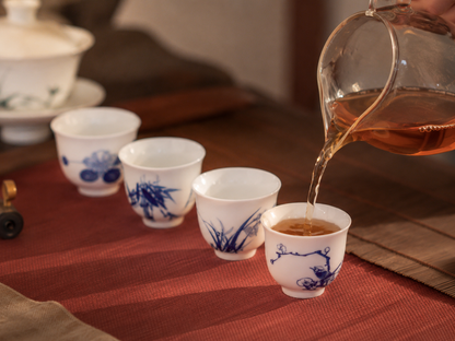 Tea poured from a glass pitcher into the Plum cup, with the other Four Gentlemen porcelain cups nearby