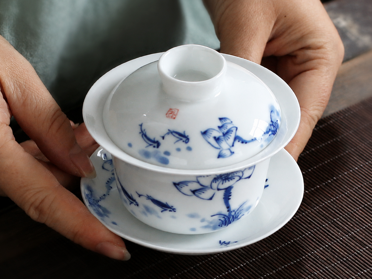 Hands holding the complete blue and white gaiwan to show its scale