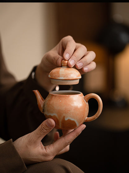 Hands lifting the lid from a Liting handmade ceramic teapot
