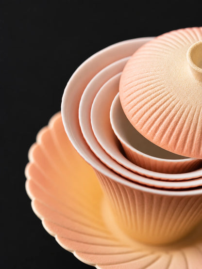 Nested gradient ceramic tea set showing white glazed interiors and ribbed surfaces
