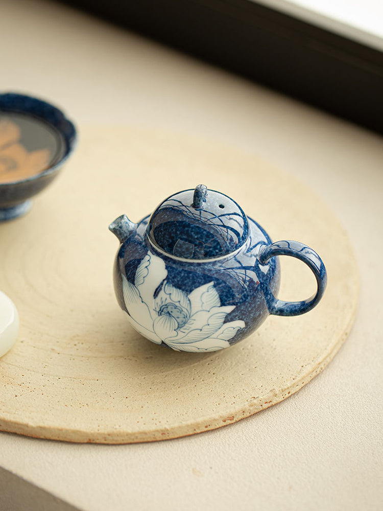 Open blue lotus ceramic teapot showing the lid opening and interior

