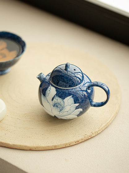 Open blue lotus ceramic teapot showing the lid opening and interior
