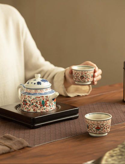 Lotus ceramic tea set with one matching cup held during a quiet tea moment