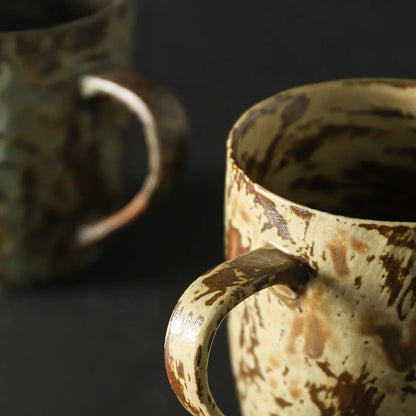 Close-up of the rounded handle and layered reactive glaze on the ceramic coffee mug
