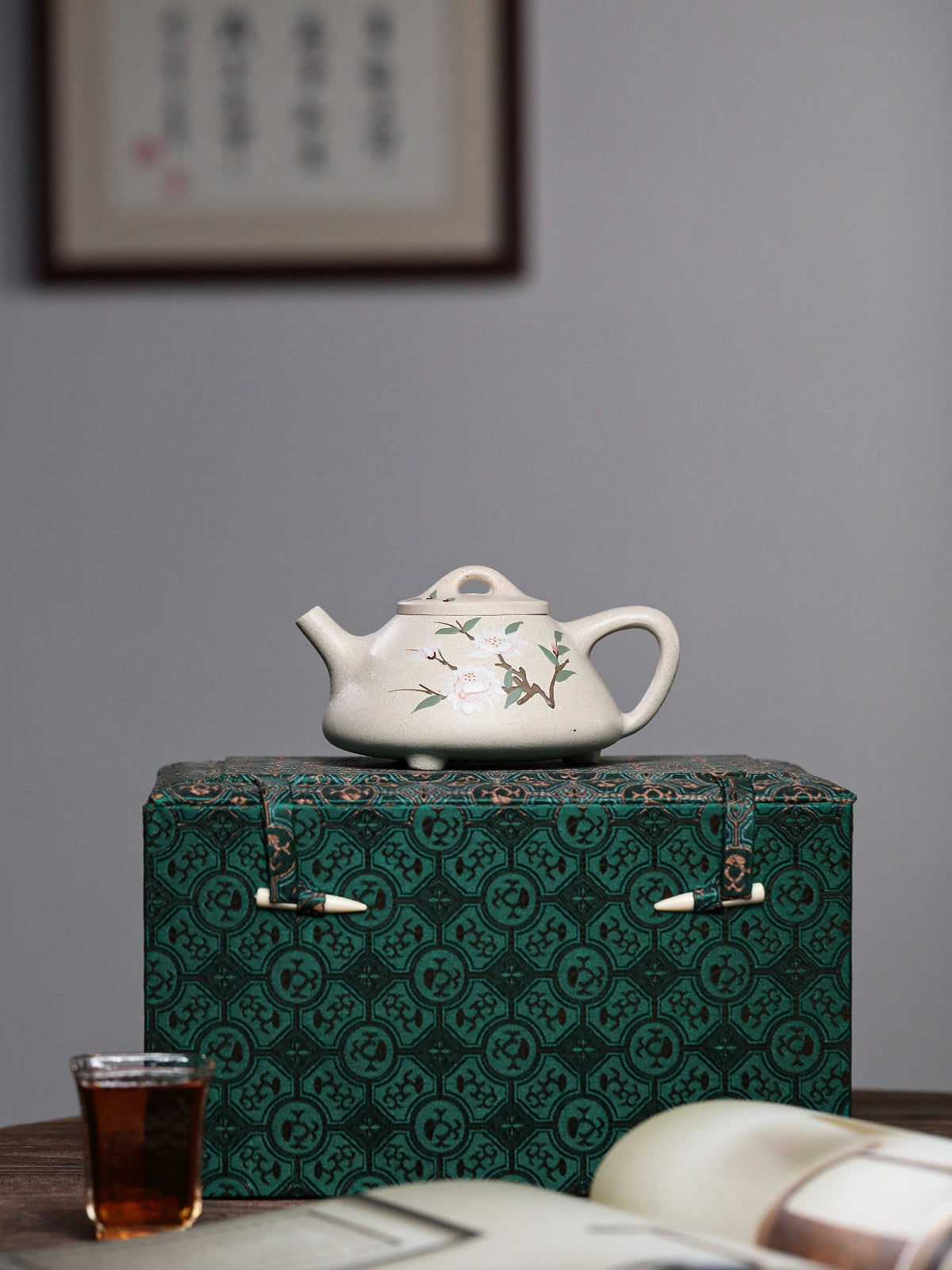 Floral side of the white duanni teapot displayed on a sample patterned gift box