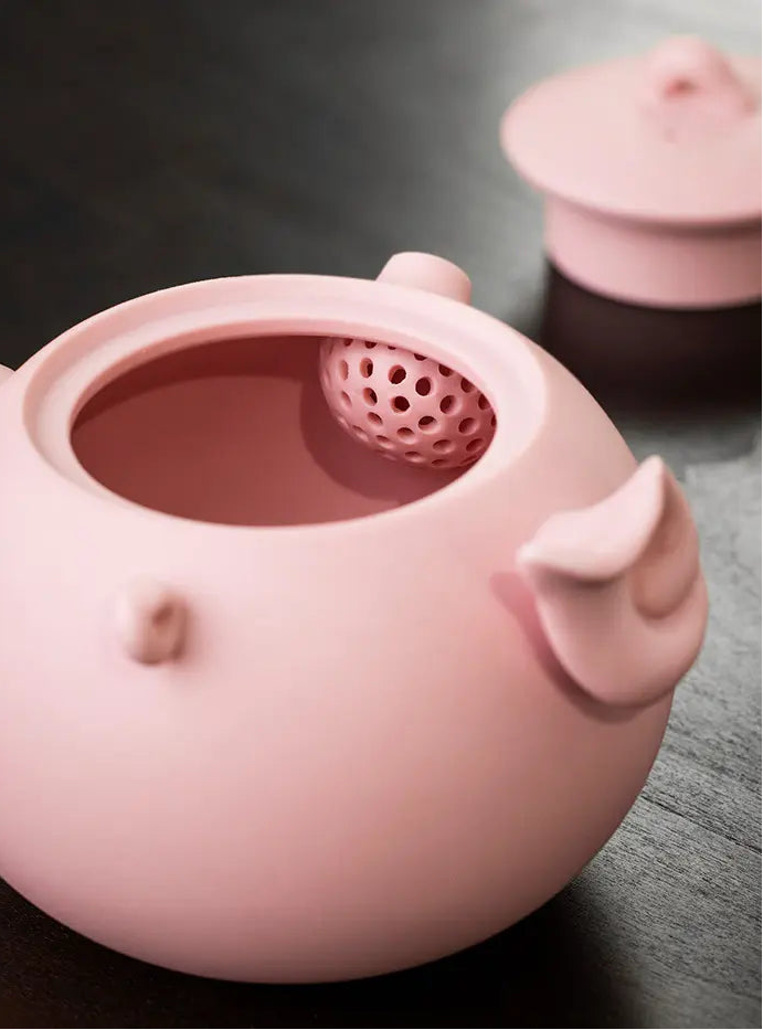 Open pink zisha teapot showing the built-in multi-hole filter
