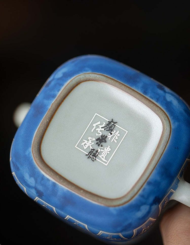 Underside of the square ceramic teapot showing its base and maker’s mark
