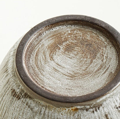 Close-up of the flat ceramic coffee cup base with handmade circular brush marks