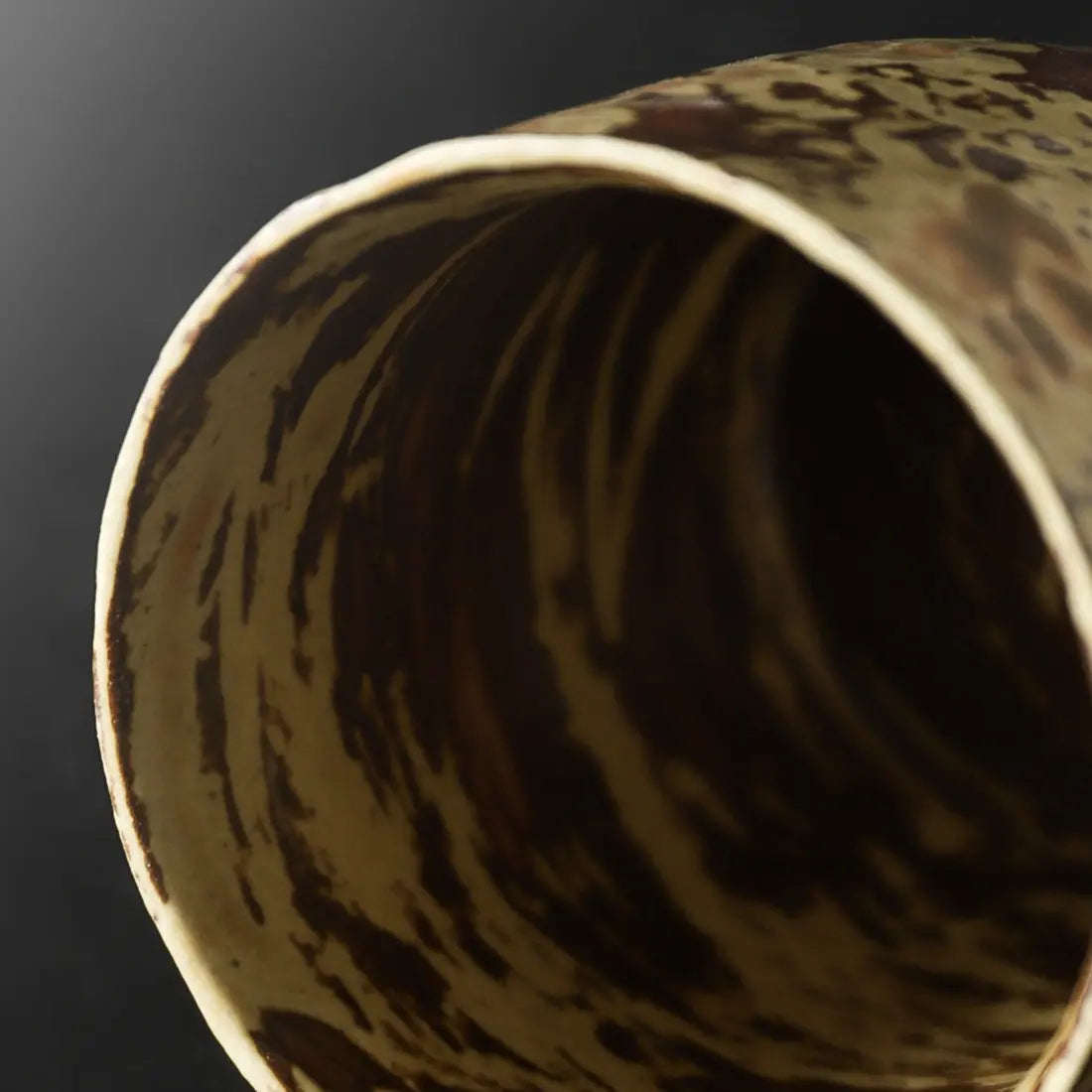Close-up of the dark flowing glaze inside the handmade ceramic coffee mug
