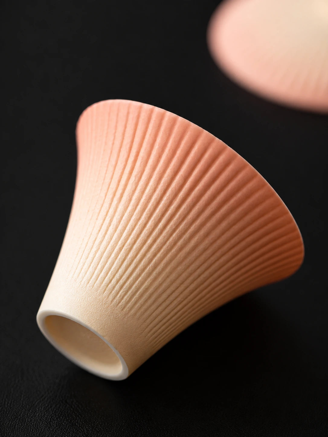 Close-up of the matte firework ribbing on a gradient ceramic tasting cup
