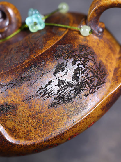 Close-up of the hand-carved mountain and pavilion scene with green bead detail on the zisha teapot
