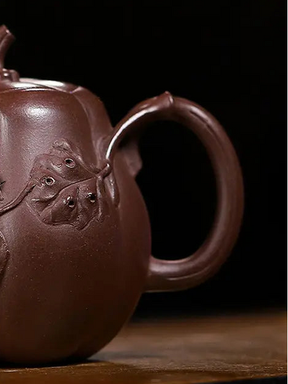 Close-up of the loop handle and raised leaf relief on a pumpkin-shaped zisha teapot