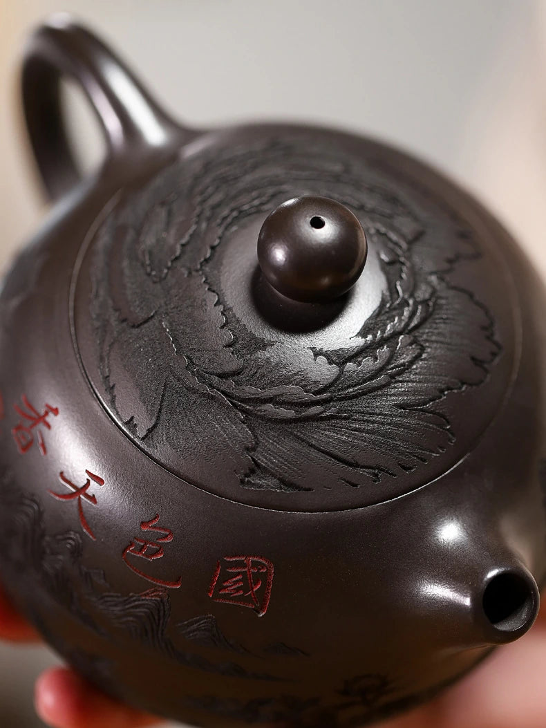 Close-up of the teapot lid carving, short spout, and red Chinese inscription