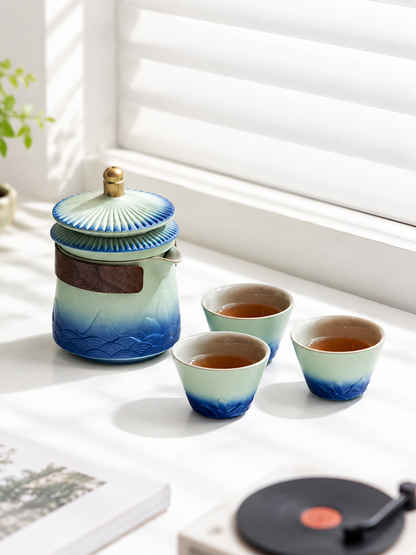 Jingdezhen ceramic tea set with one teapot and three cups by a window

