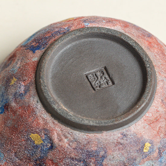 Close-up of the teapot base with its stamp and mottled glaze
