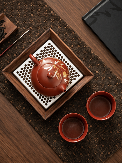 Top view of Yixing zisha teapot and two matching tea cups on tea tray