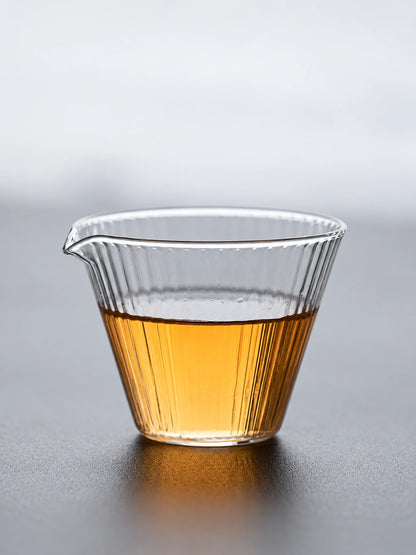 Clear high-borosilicate glass tea pitcher with ribbed sides and amber tea
