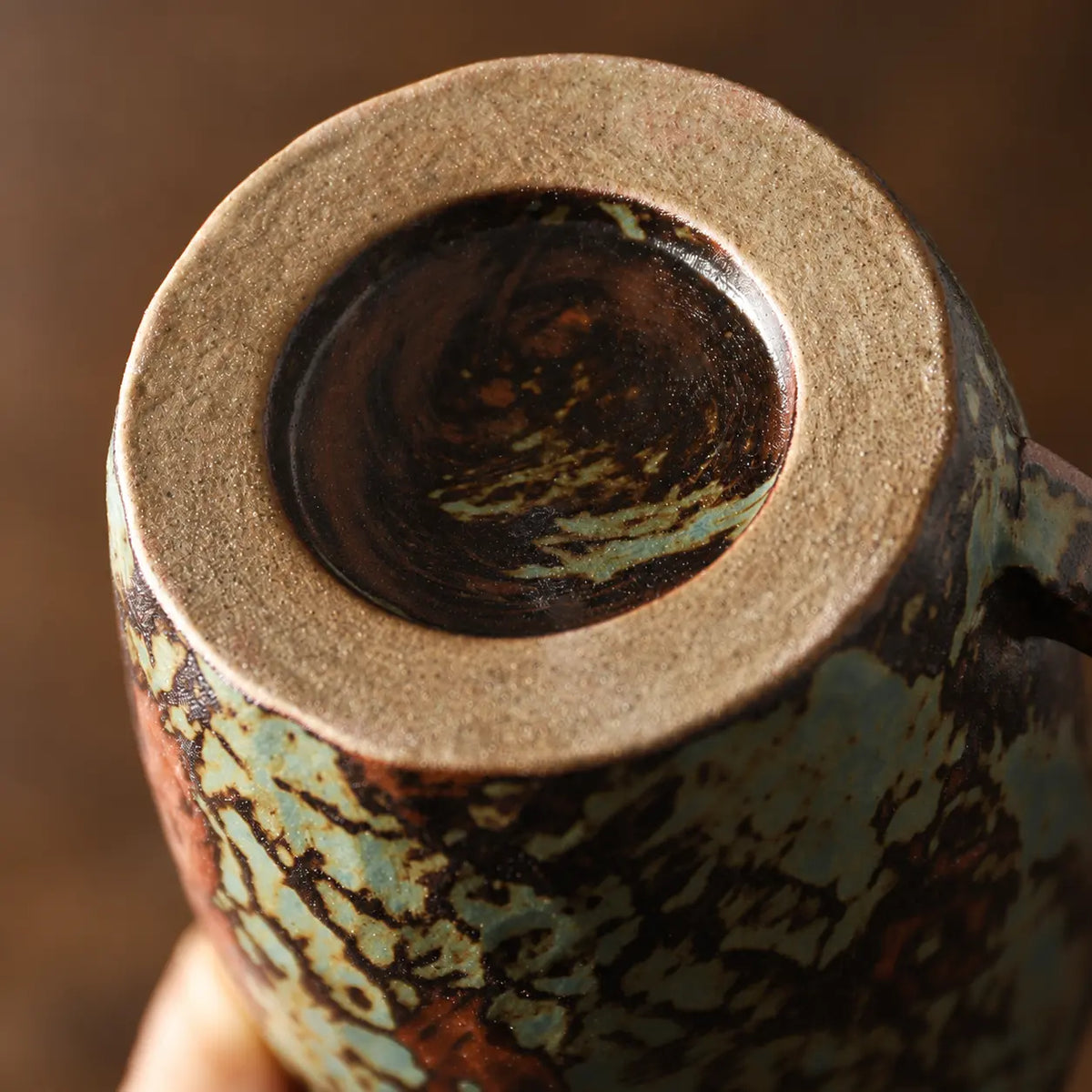 Close-up of the unglazed foot ring and kiln-fired base of the ceramic coffee mug
