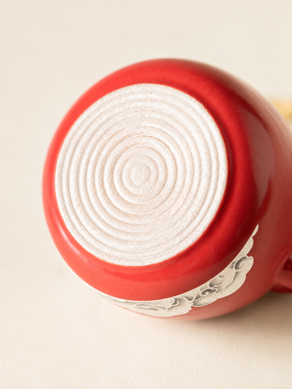 Unglazed foot and concentric rings on the base of a red ceramic teacup
