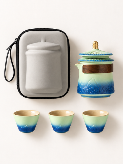 Top-down view of teapot, three cups and gray travel bag
