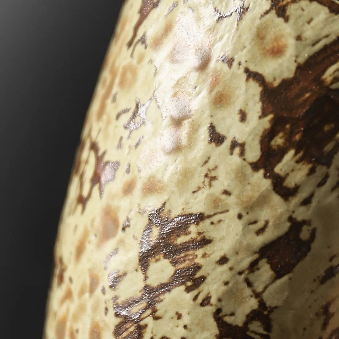 Close-up of the mottled brown and Mango Yellow reactive glaze texture
