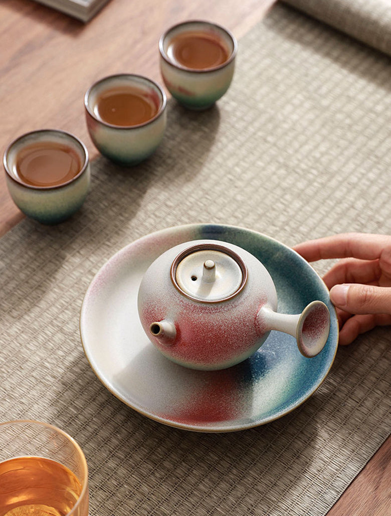 Overhead tea setting with a side-handle ceramic teapot and three teacups