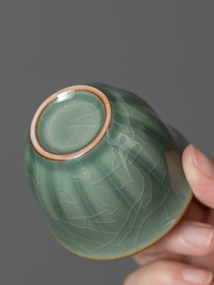 Close-up of the circular foot and crackle glaze on a green ceramic tasting cup
