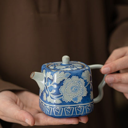 Handheld view showing the compact scale of the blue peony ceramic teapot
