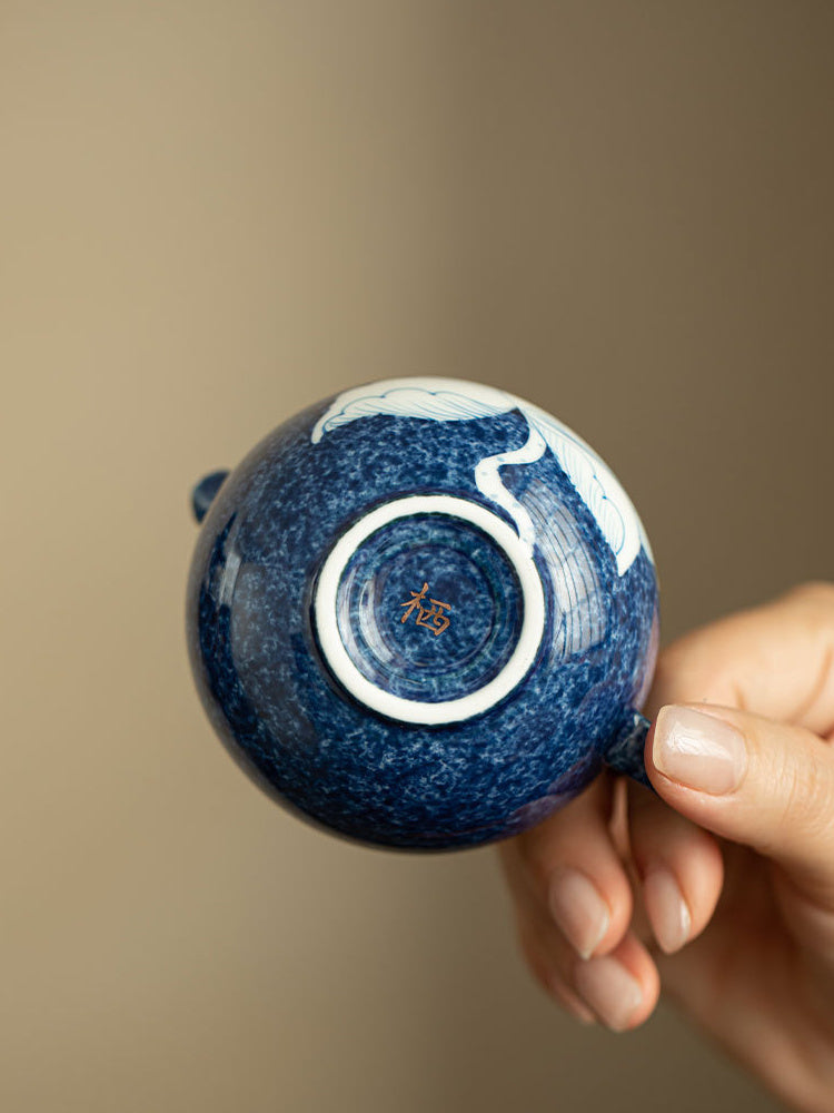 Close-up of the ceramic teapot base, original stamp, and deep blue glaze

