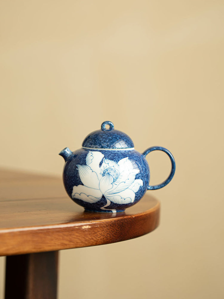 Blue and white lotus ceramic teapot in a minimalist interior setting
